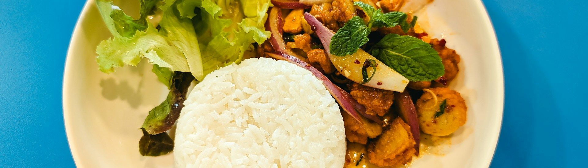 Thaimaalainen annos riisillä ja tuoreella salaatilla BKK by Thai Food Companyssa
